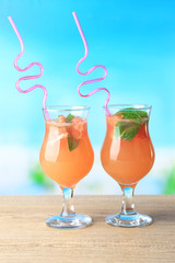 Grapefruit cocktail with cocktail straw on bright background