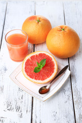 Half of grapefruit, glass of fresh juice and spoon