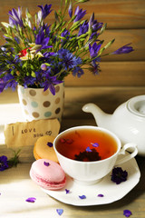 Cup of fresh herbal tea on wooden table