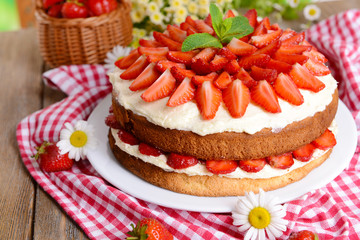 Delicious biscuit cake with strawberries on table close-up