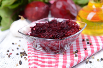 Grated beetroots in bowl on table close-up