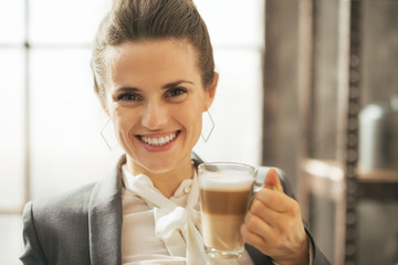 Portrait of smiling business woman drinking coffee latte