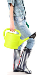Young woman in rubber boots holding watering can, isolated