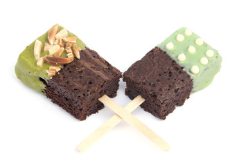 Chocolate cake with green tea coated on stick .