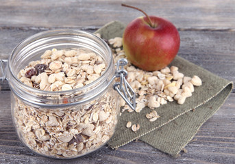 Homemade granola in glass jar and fresh apple,