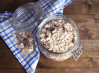 Homemade granola in glass jar, on color wooden background