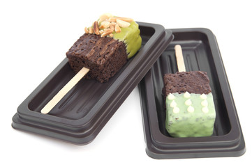 Chocolate cake with green tea coated on stick .