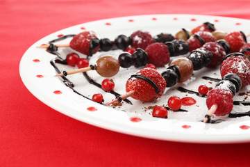 Fresh fruit kebabs for healthy snack on plate close up