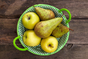 Fresh green apples and pears on a wooden table
