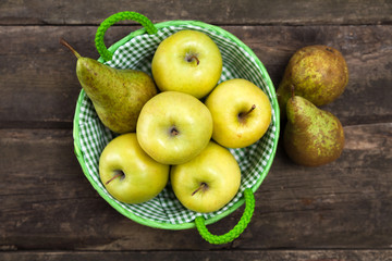 Fresh green apples and pears on a wooden table