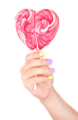 Female hand with stylish colorful nails holding lollipop,