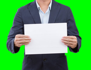 Business man holding blank paper isolated on green background