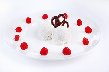 Creamy ice cream with raspberries on plate, isolated on white