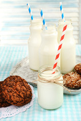 Milk in bottles with paper straws on table