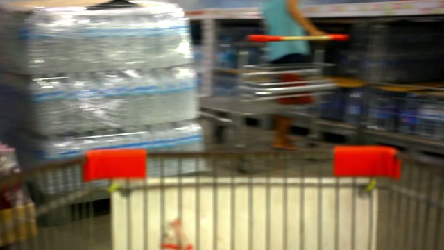 Customer shopping at supermarket with trolley. Video