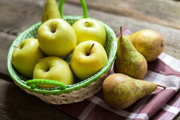Fresh green apples and pears on a wooden table