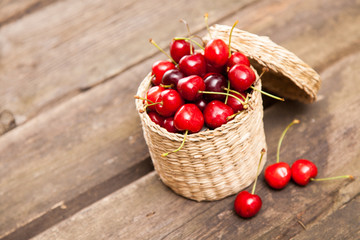 Fototapeta na wymiar Juicy cherries in a wicker basket