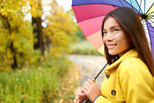 Woman happy with umbrella under the rain