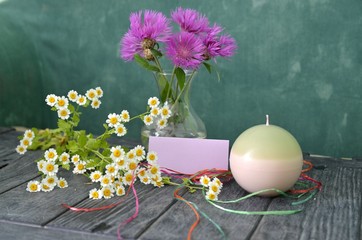 Blumen mit Kerze und Schild