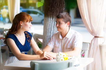 Outdoor portrait of young sensual couple in summer cafe. Love an