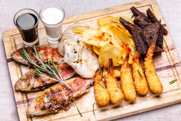Trout, squid and prawns on a wooden board