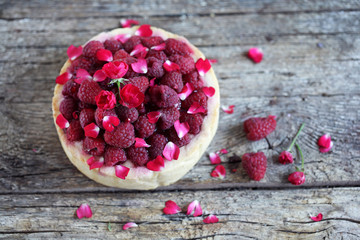 Pie or cake topped with fresh raspberries and rose petals