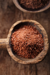fine grated chocolate in old wooden spoon