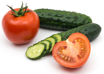 Two green cucumber and tomatoes on a white background