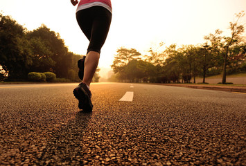 healthy lifestyle young woman legs running on sunrise road