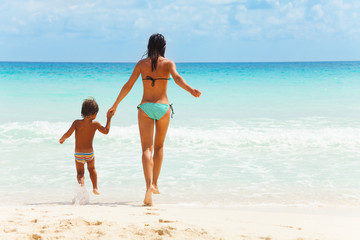 Child and woman holding hands on sea background