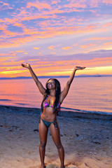 Beautiful black African American woman posing on the beach at su