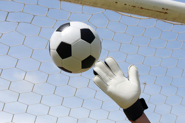 goalkeeper's hands reaching foot ball