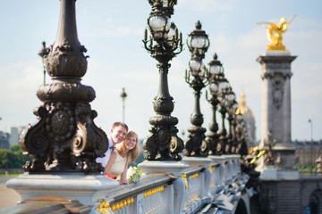 Fototapeta na wymiar Just married couple on the Alexandre III bridge