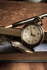 Pocket watch with antique book and pen
