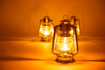 Burning three kerosene lamps background, concept light