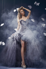 Beauty blonde woman on the fog with butterflies