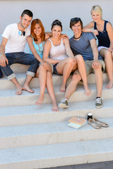 Fototapeta premium Happy college students sitting on stairs summer