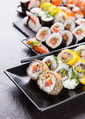 Delicious sushi pieces served on black stone