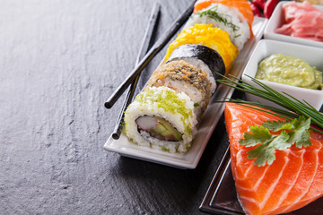 Delicious sushi pieces served on black stone