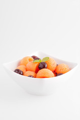 Macedonia di melone e ciliegine isolata su sfondo bianco