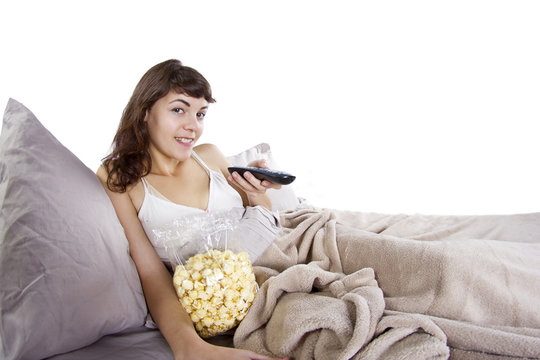 Young Teenager Watching Movies In Bed With Popcorn