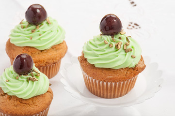 Cupcake verdi con ciliegina  isolati su sfondo bianco