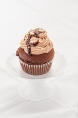 Cupcake al cioccolato su un'alzatina isolato su sfondo bianco