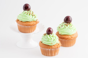 Cupcake  verdi con ciliegina  isolati su sfondo bianco