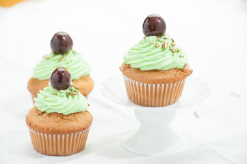Cupcake  verdi con ciliegina  isolati su sfondo bianco