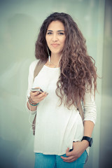 beautiful curly long brunette hair moroccan woman using smart ph