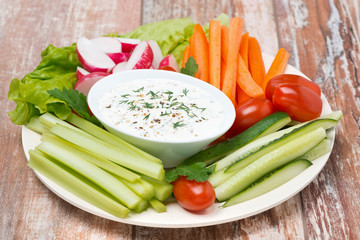 plate with fresh vegetables and yoghurt sauce