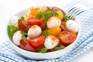 salad with mozzarella and colorful cherry tomatoes in a bowl