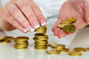 Frau mit Münzstapel beim Geld sparen