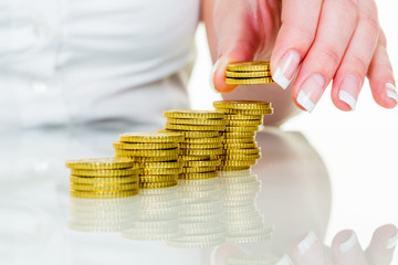 Frau mit Münzstapel beim Geld sparen